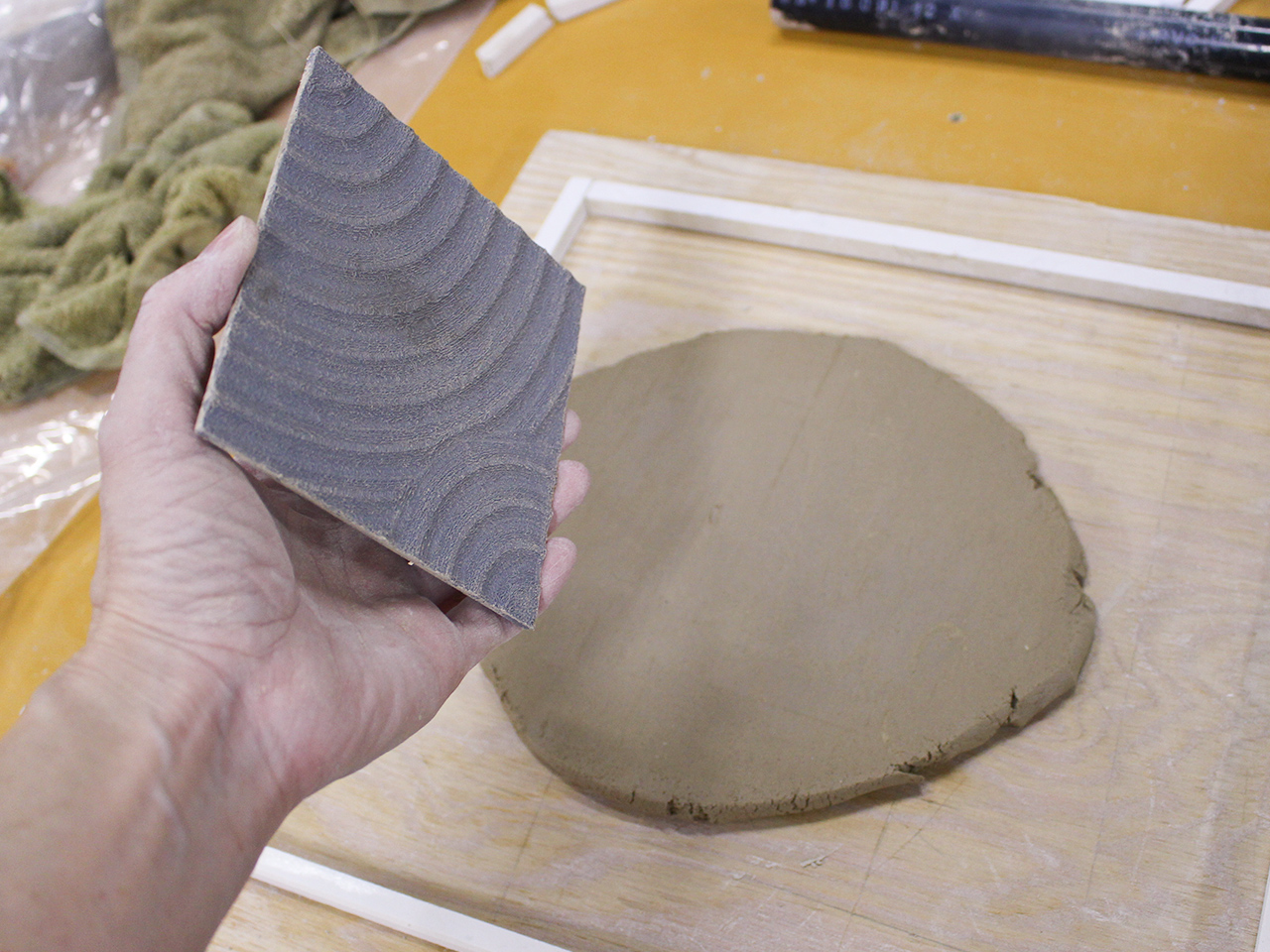 粘土に型を使って模様をつけ、タイルの大きさにカット。
